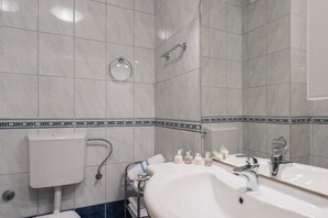 A bathroom with a white sink, a mirror, a towel rack, and a toilet. - Apartment Blue Lagoon - One Bedroom Apartment (Split)
