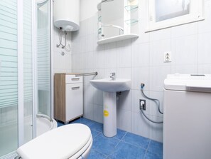 Une salle de bain moderne équipée de toilettes, d’un lavabo et d’une douche.