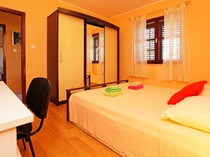 Une chambre avec un lit, un bureau et une armoire.