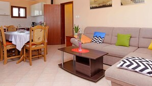 Un salon comprenant un canapé, une table basse et un coin repas avec une table et des chaises.