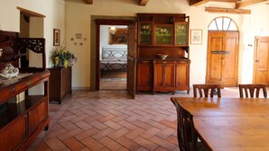 Una habitación amplia con suelo de espiga, vigas de madera en el techo y un armario de madera tradicional.