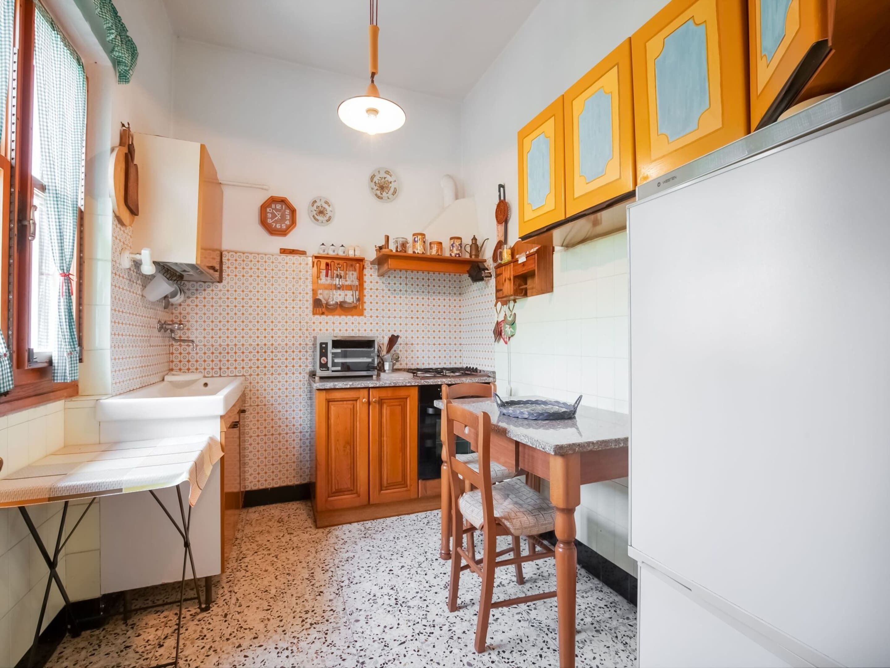 A compact kitchen with a sink, stove, and wooden cabinets.