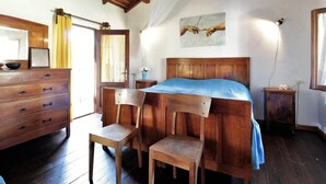 A rustic bedroom with a wooden bed, a wooden dresser, and a chair. - Mountain Hideaway for Four (Santa Giustina)