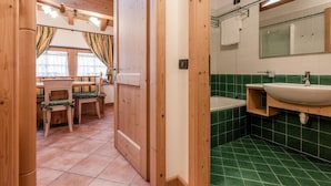 Een houten interieur met een eethoek en een badkamer.