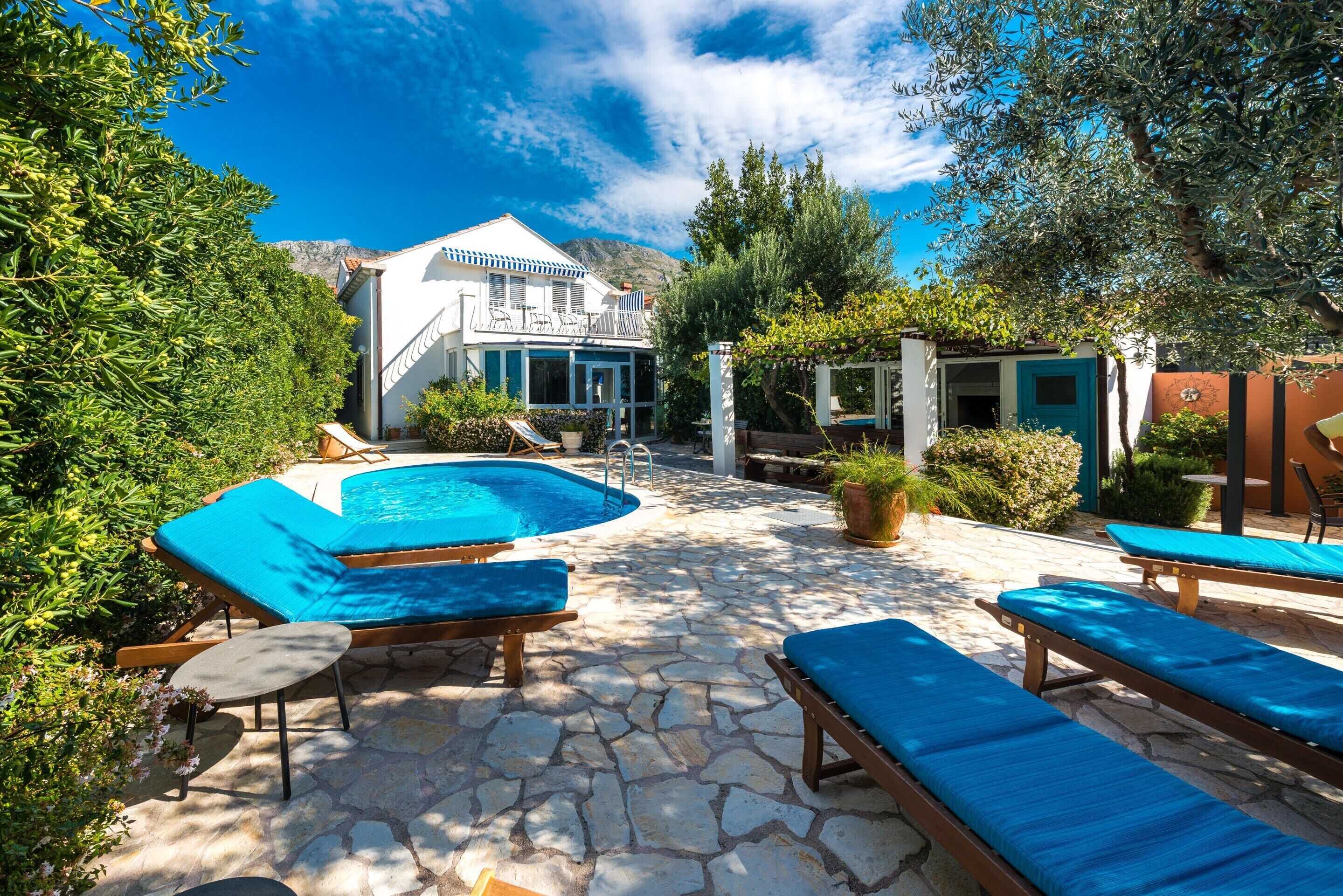 A pool area with lounge chairs and a stone patio.