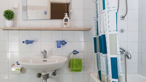 A bathroom with a sink, mirror, shower, and a green towel on the floor. - Sunset Bay Room - Double Room With Terrace and Partial Sea View (Dubrovnik)