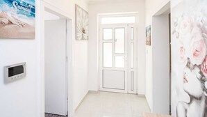 A hallway with a white door, a thermostat, and a floral painting. - Apartments Blazevic - Comfort Two Bedroom Apt With Hot Tub and Sea View (Zupa dubrovacka)