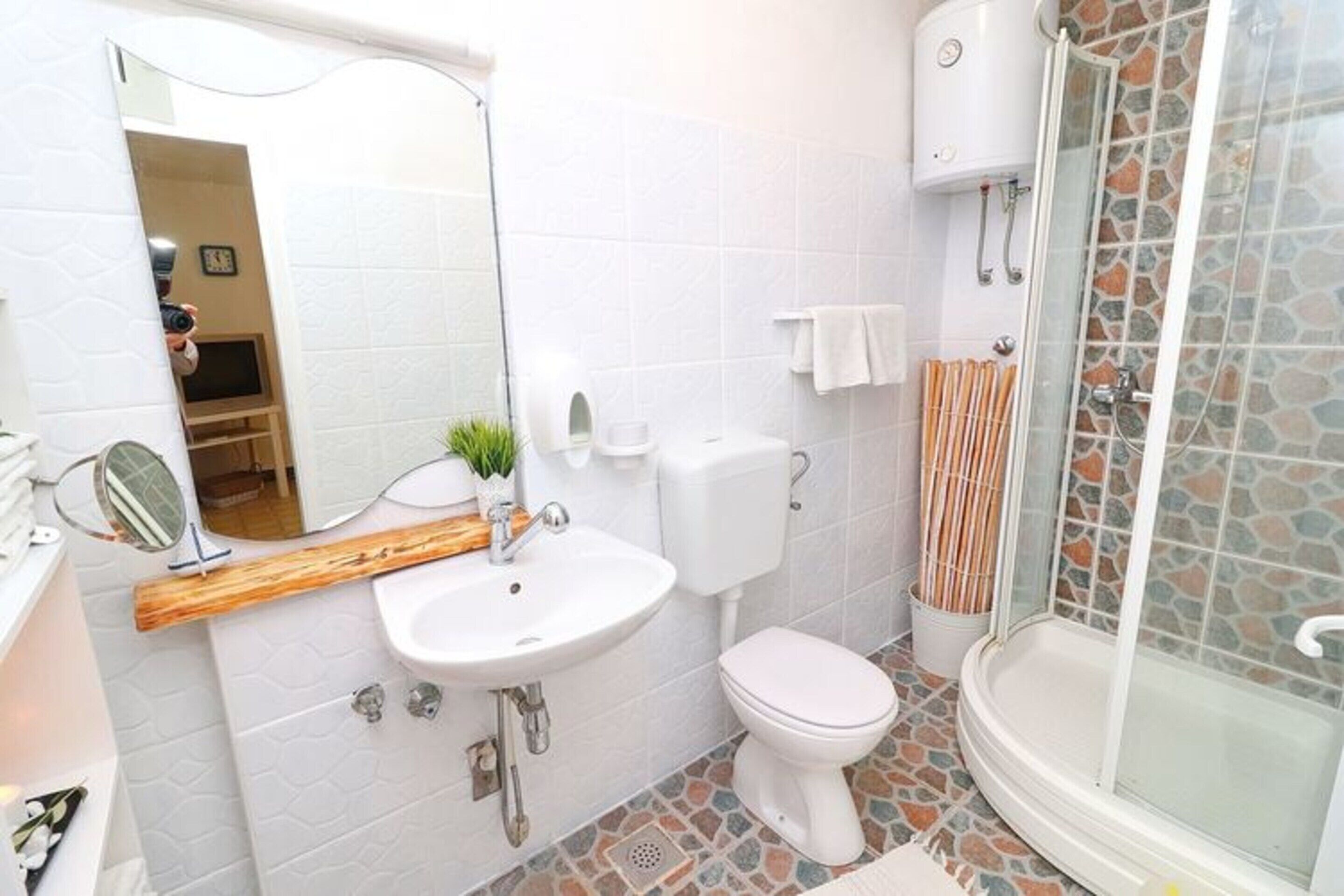 A bathroom with a white sink, toilet, and shower.