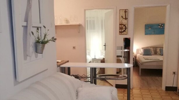 A cozy living area with a white sofa, a small table, and a blue accent wall. - Apartments Mediterranean House - Two Bedroom Apartment With Terrace (Slivno)