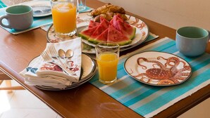 A breakfast table with plates of food, glasses of orange juice, and a stack of napkins. - Apartments Bonavista - Superior Two Bedroom Apartment With Balcony and Sea View (Dubrovnik)