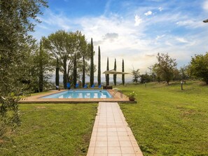 A swimming pool with a tiled deck, surrounded by grass and trees. - Classic Villa for Family With Pets (Bevagna)