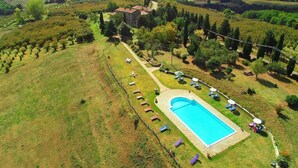 An aerial view of a property with a swimming pool, surrounded by a well-maintained lawn and trees. - Belvilla by OYO Mansion in Orvieto (Orvieto)
