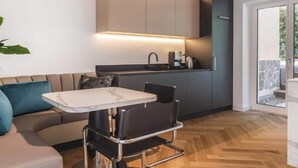 A modern kitchen with a built-in stove, a sink, and a countertop. There is a dining area with a table and chairs.