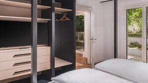 A bedroom with a bed, a wardrobe, and a sliding glass door leading to an outdoor area.