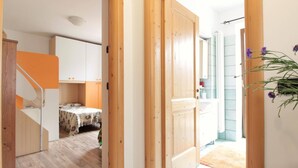 A hallway with wooden doors leading to a bedroom and a bathroom. - Family Retreat Near Garda (Ronzo-Chienis)