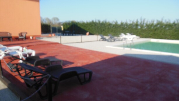 A pool area with lounge chairs and a red floor. - Venetian Villa With Pool and Sauna (Codevigo)