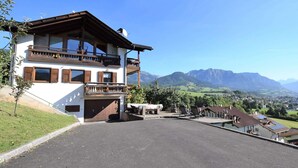 A two-story chalet with a balcony, a driveway, and a view of mountains. - Large Apartment With Terraces in Val di Fiemme (Ville di Fiemme)
