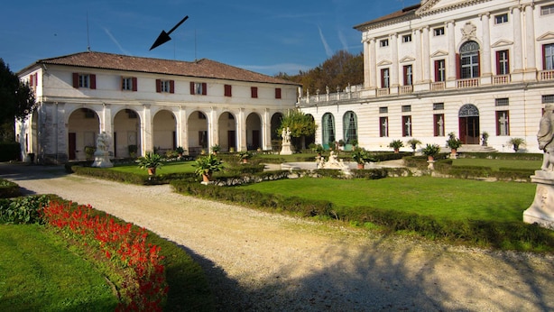 Ein historisches Gebäude mit Innenhof, Bogenwegen und Statuen.