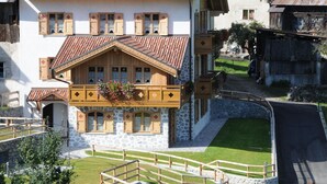 A traditional chalet with a stone facade, wooden balconies, and a sloped roof. - Belvilla by OYO Maso Margherita Quadrilocale (Commezzadura)