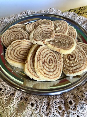 Un plato de rollos de canela sobre un mantel de encaje.