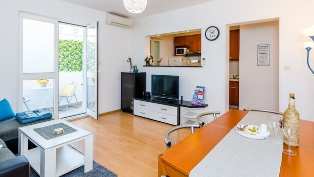 Um apartamento moderno com sala de estar, área de refeições e cozinha.