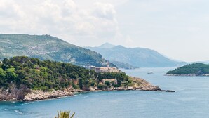 Un paisaje costero con un conjunto de edificios históricos en una colina, con vistas al mar.