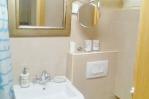 A bathroom with a sink, mirror, and two soap dispensers. - Apartment Rita - One Bedroom Apartment (Ston)