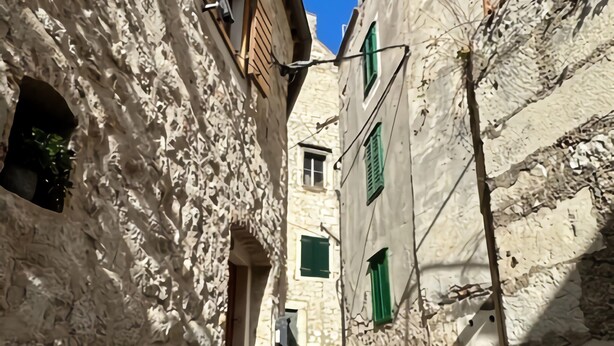 A narrow street with stone buildings, a staircase, and green shutters. - Holiday Home in Bilice With Pool (Bilice)