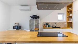 A modern kitchen with a wooden countertop, a built-in stove, and a backsplash. - Holiday Home in Bilice With Pool (Bilice)