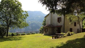 A rustic stone building with a sloped roof, a wooden bench, and a fenced area. - Holiday Home in Cison With Mountain Views (Cison di Valmarino)