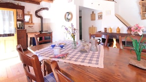 A dining area with a wooden table, chairs, and a floral centerpiece. - Alpine Getaway for Families (Lamon)
