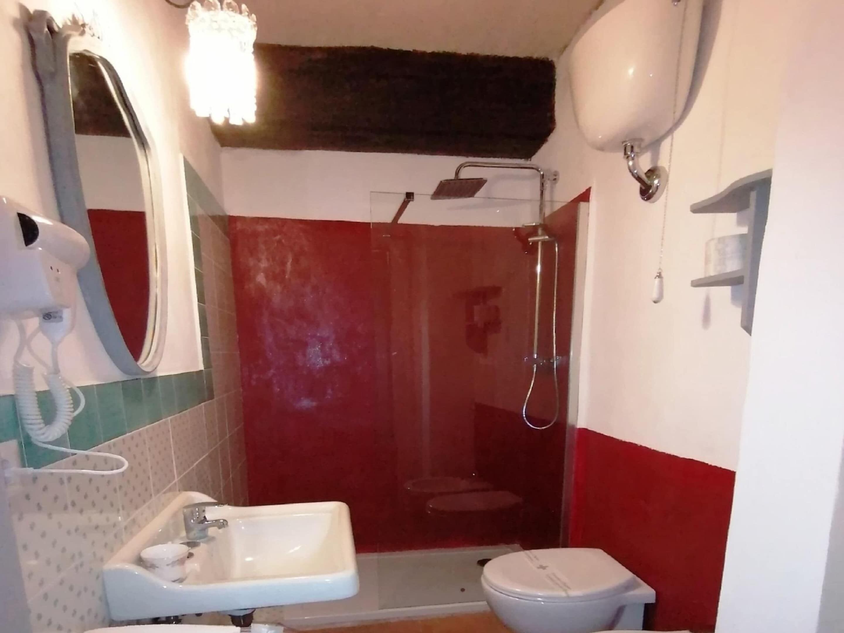 Ein Badezimmer mit Dusche, Toilette, Waschbecken und Fön.