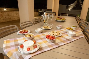 Enjoy a casual meal al fresco with a beautifully set table amidst a serene outdoor setting.