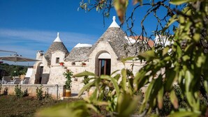 A stone building with conical roofs, a door, and potted plants. - Huge Villa With Private Pool in Salento, Italy (Ceglie Messapica)