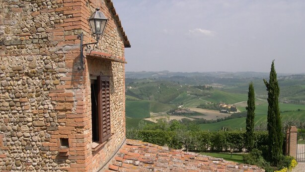 A stone building with a brick roof, a window with shutters, and a view of rolling hills. - Countryside Home With Private Terrace (Castelfiorentino)