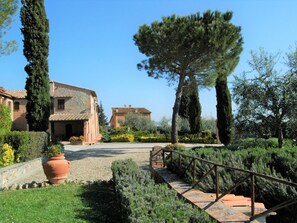Escape to a serene garden oasis with a traditional stone building surrounded by lush greenery and a tranquil atmosphere.