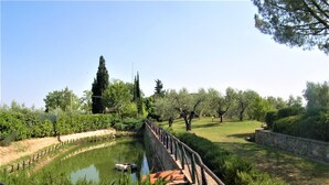 A canal with a boat, surrounded by greenery and trees. - Apartment in Castelfiorentino With Pool (Castelfiorentino)
