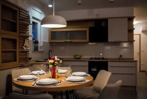 Enjoy meals with family and friends at this stylish dining area, featuring a round table for four and a beautiful vase of flowers.