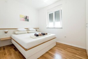 Cozy retreat with a single bed, wooden headboard, and a window with blinds.