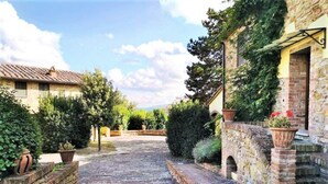 A stone pathway leading to a building with a yellow facade and a stone archway. - Holiday Home in Gambassi Terme With Terrace (Gambassi Terme)