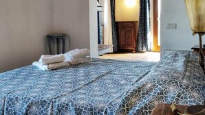 A bedroom with a bed, a bedside table, a lamp, and a door leading to another room. - Holiday Home in Gambassi Terme With Terrace (Gambassi Terme)