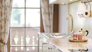 A kitchen with a window, a sink, and a coffee maker.