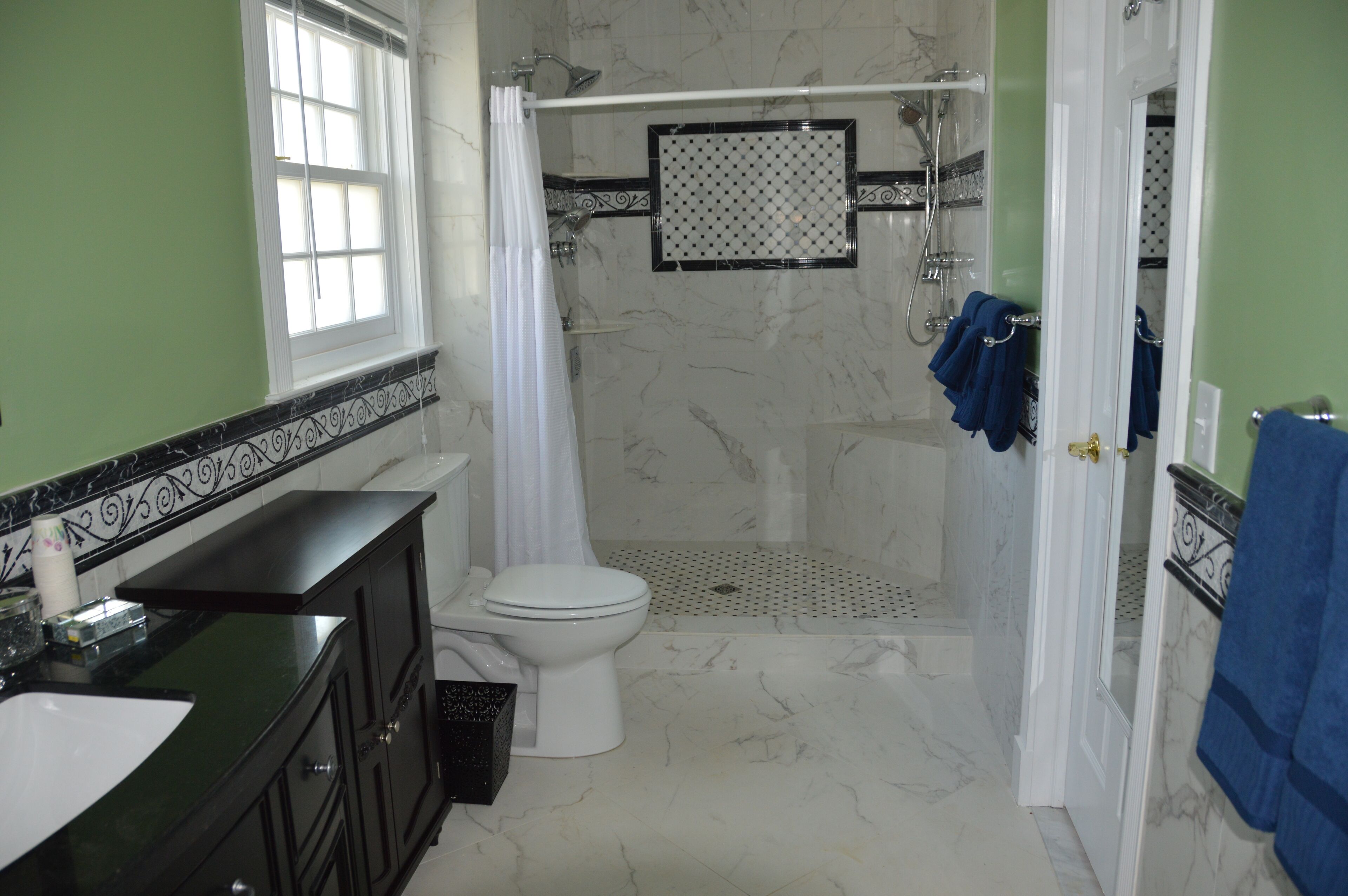 Un baño con ducha, inodoro y tocador.