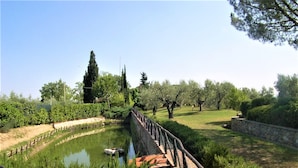 A canal with a boat, surrounded by greenery and trees. - Farmhouse in Castelfiorentino With Pool (Castelfiorentino)