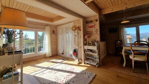 A cozy room with wooden beams, a large window, a wooden table, and a chair. - Chalet in Marliana Near Center (Marliana)