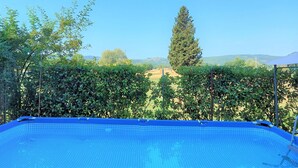 Une piscine offrant une vue dégagée sur le paysage environnant, notamment sur les arbres et les collines au loin.