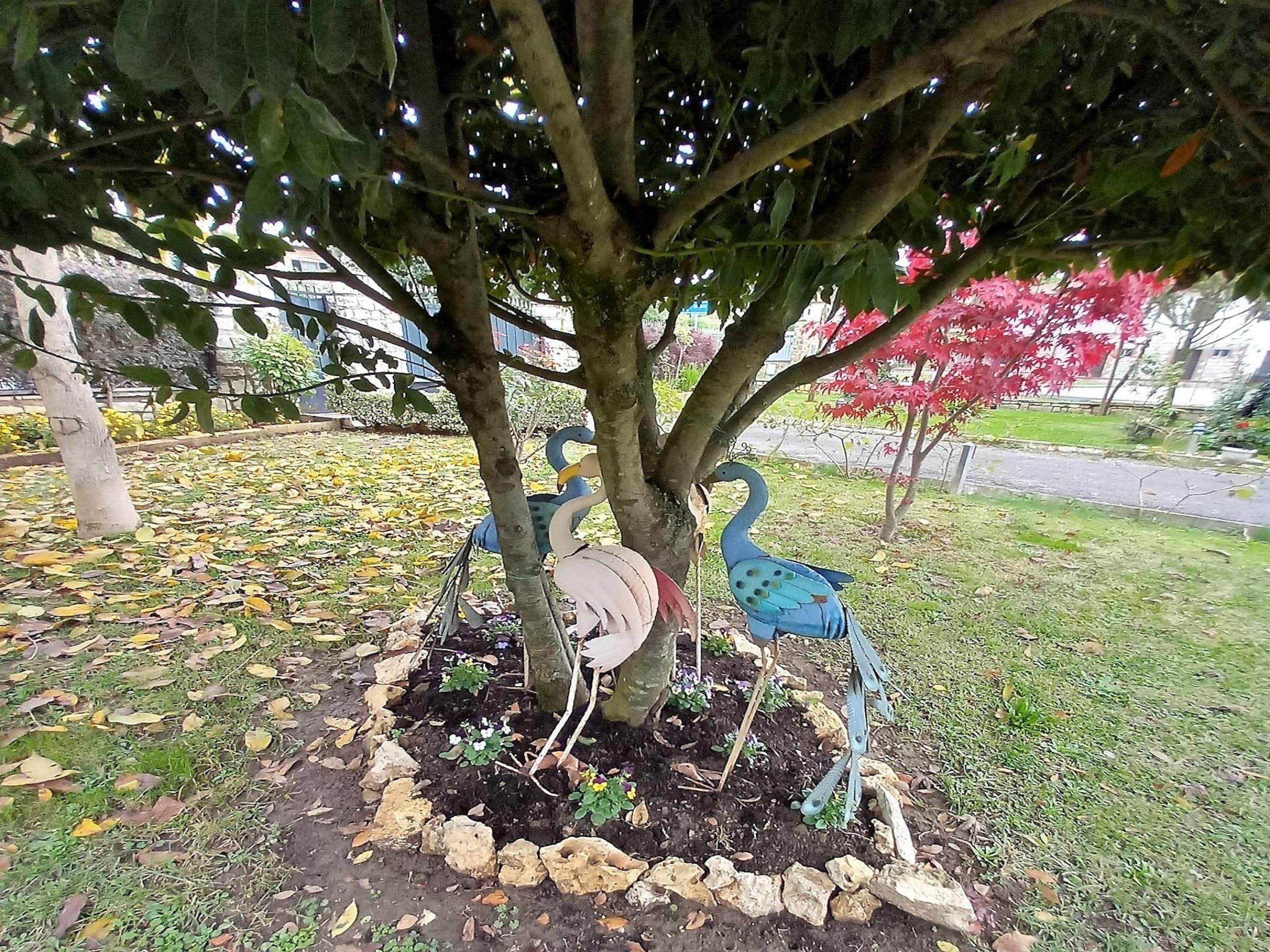 Un arbre orné d’une sculpture représentant un paon et un flamant rose.