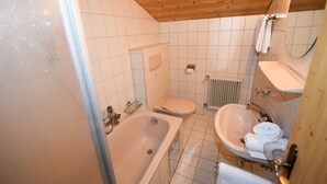 Une salle de bain avec une baignoire, des toilettes et un lavabo.