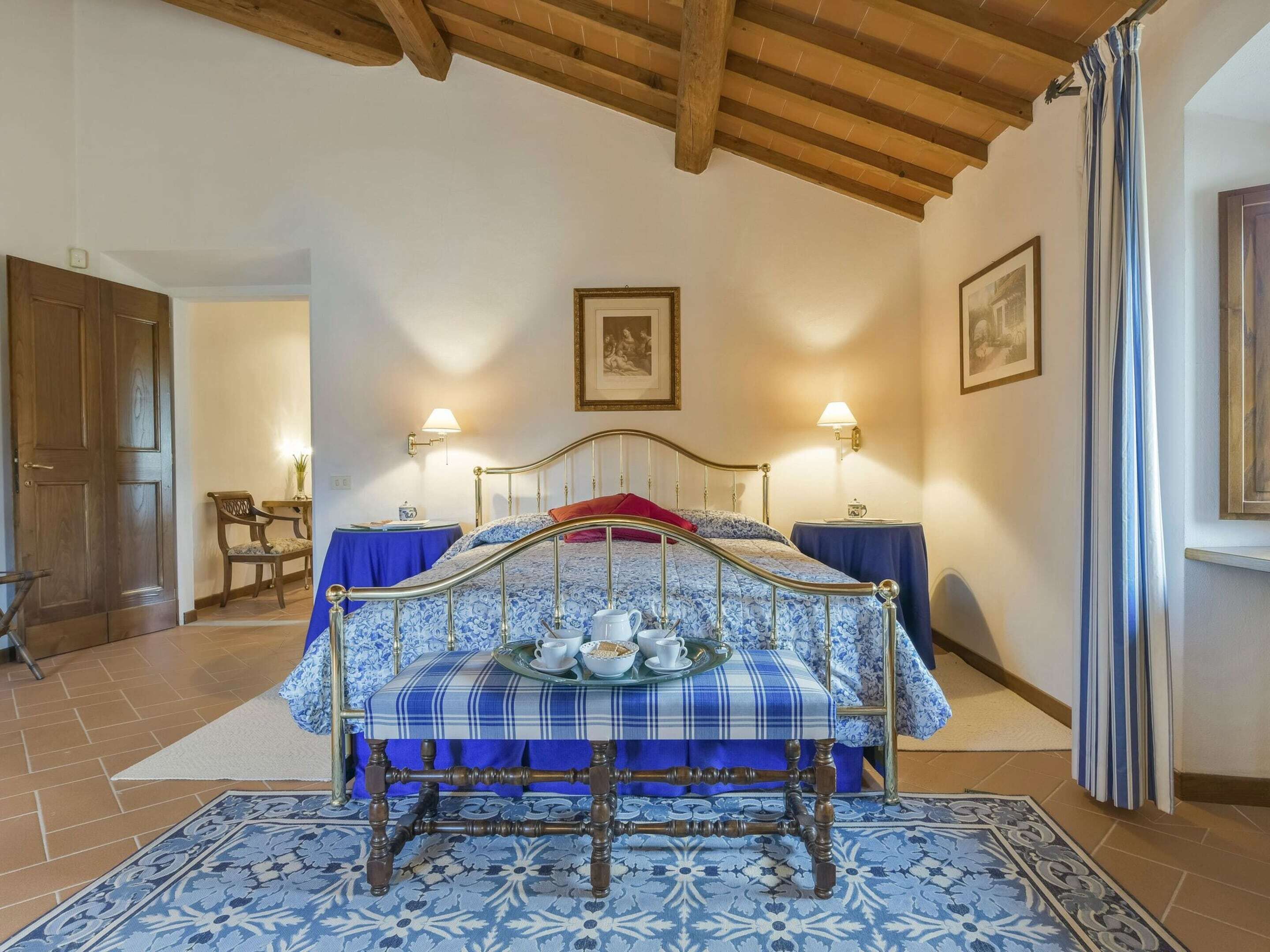 Une chambre à coucher avec un lit, des tables de chevet, une chaise et un plafond en bois.