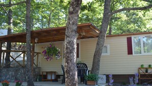 Un chalet rustique doté d’un porche abrité, d’un mur en pierre et de plantes en pot.